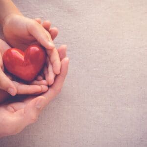 Image of two hands holding a heart shapes object