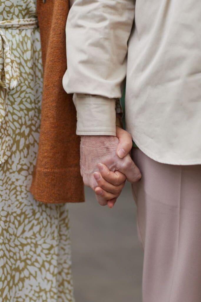 Close-up photo of a senior couple holding hands, symbolizing love and togetherness.